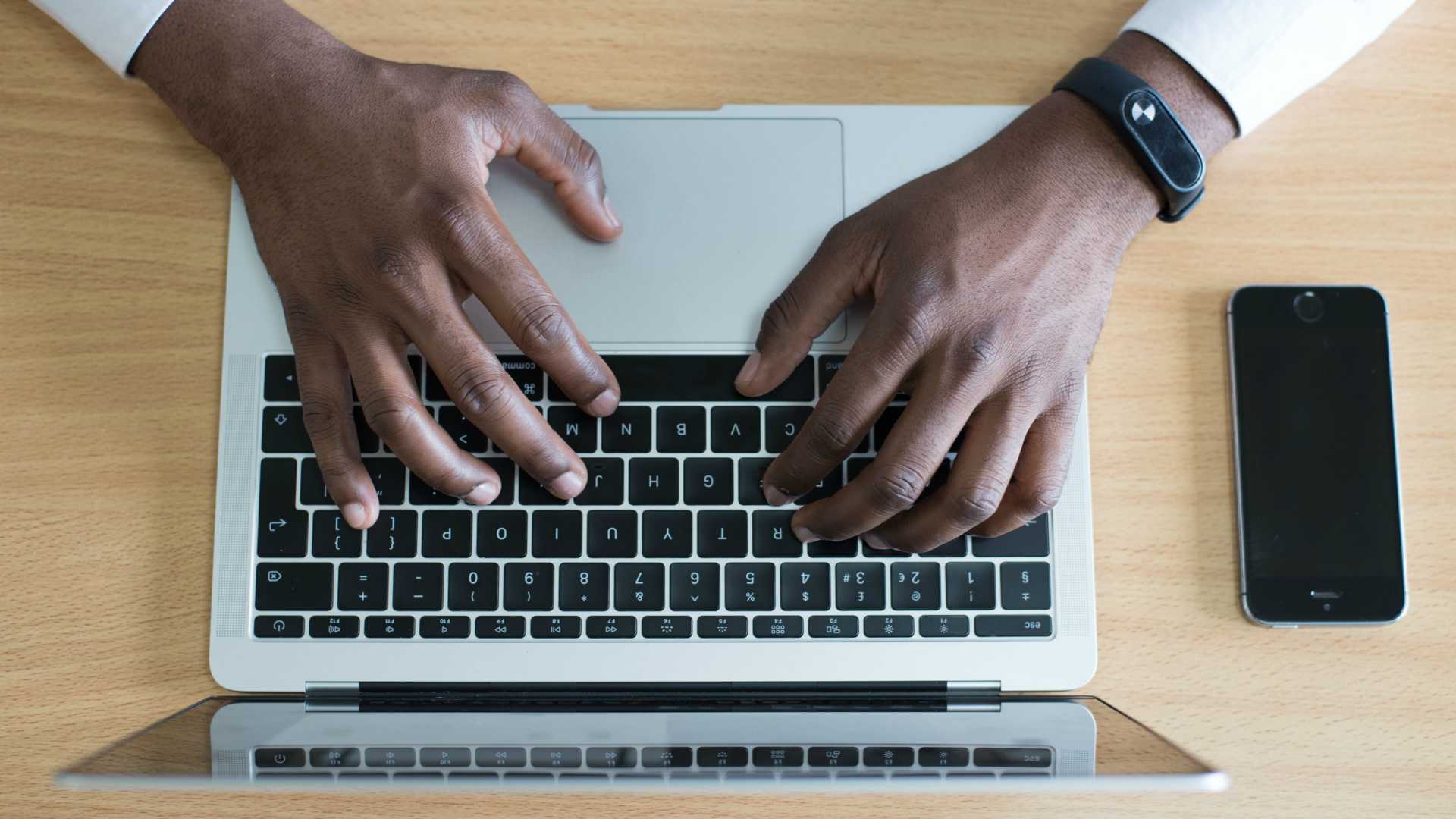 Man Typing On A Laptop With A Smartphone On His Desk - Typing - HD Wallpaper 