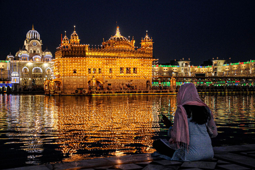 A Devotee Sits In The Backdrop Of The Illuminated golden - Golden Temple 550 Years - HD Wallpaper 