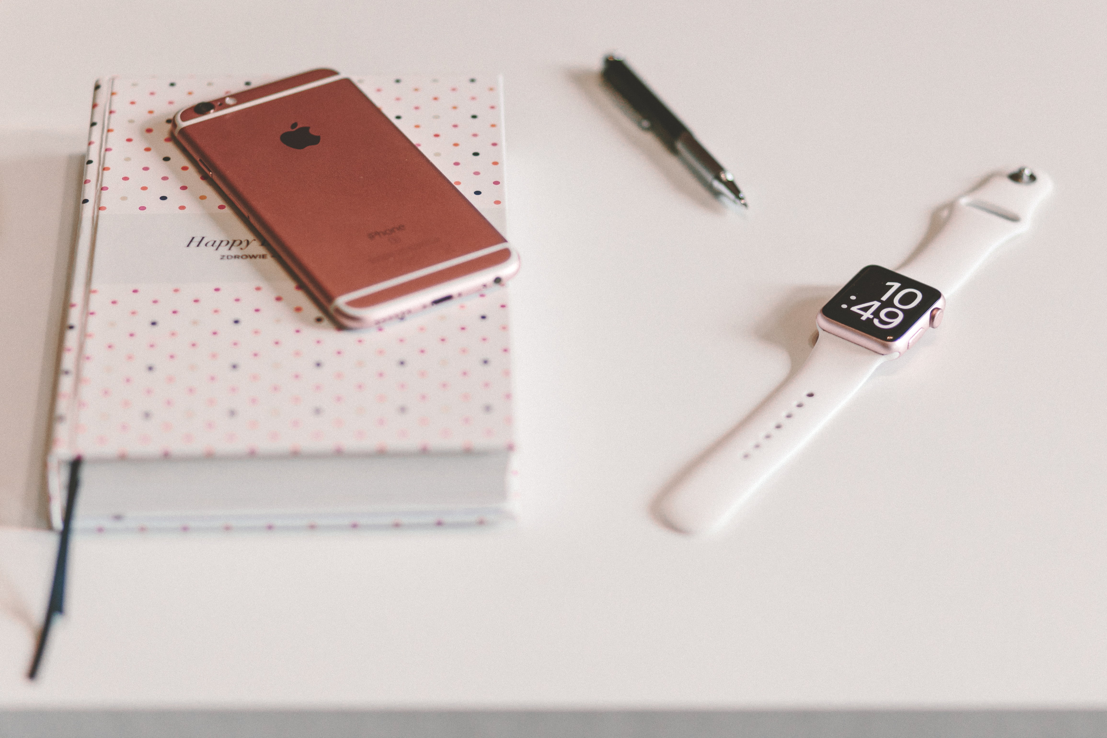 Rose Gold Iphone 6s On Top Of Book Beside Twist Pen - White Iphone Watch - HD Wallpaper 