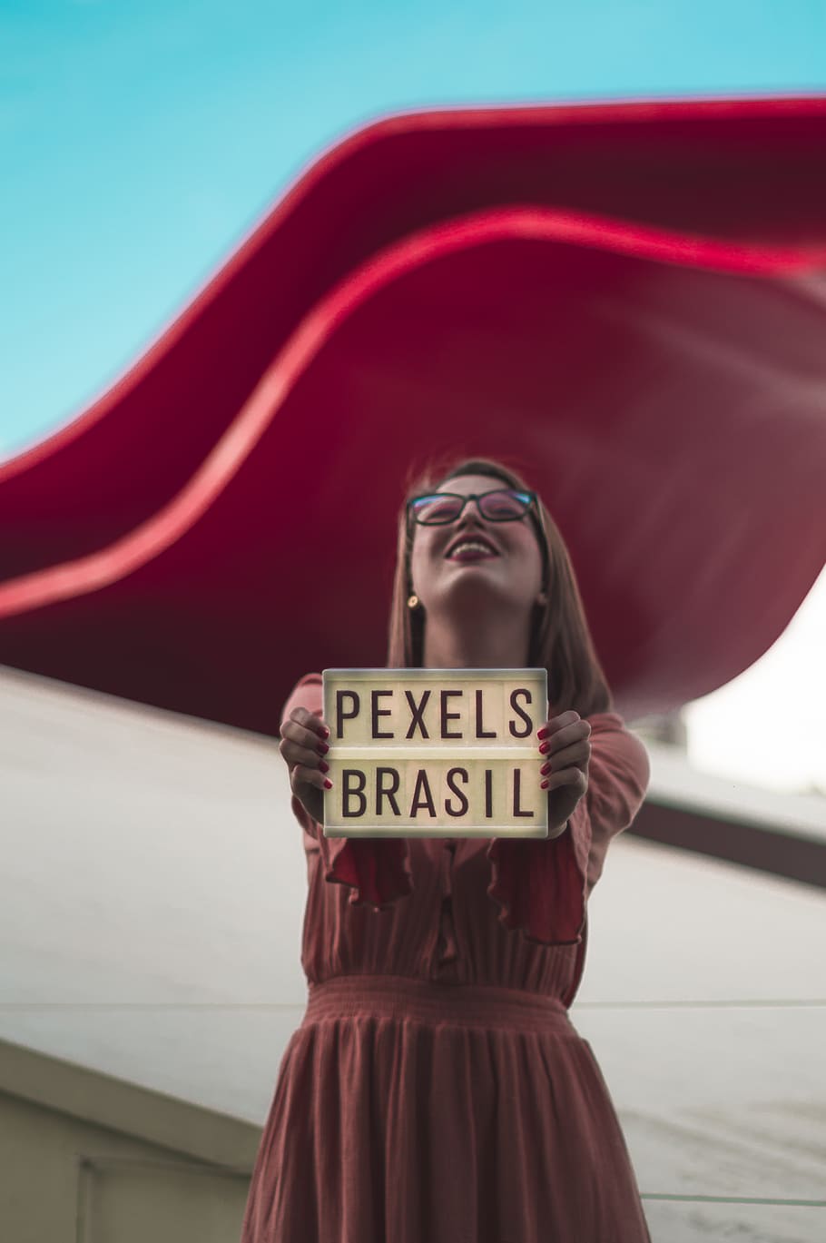 Woman Standing And Holding Pexels Brasil Sign And Smiling, - Girl - HD Wallpaper 
