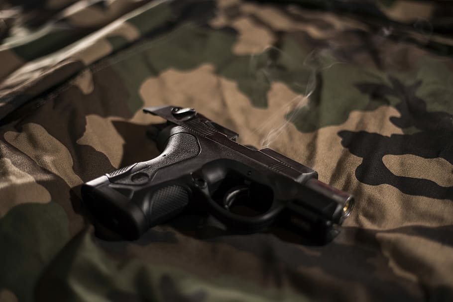 Black Pistol On Green, Brown, And Black Camouflage - Black Man Holding Revolver - HD Wallpaper 