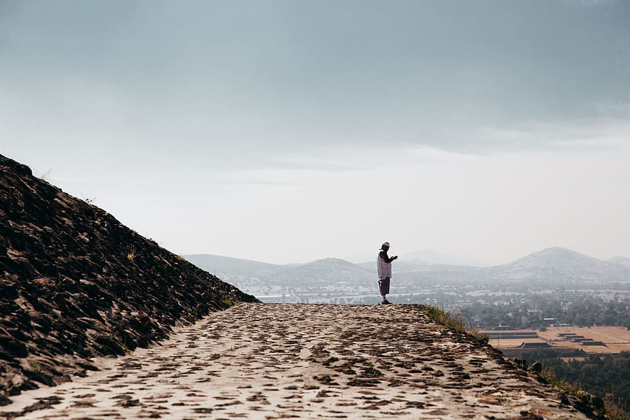 A Man Wearing Casuals Standing On The Edge Of Stone - Summit - HD Wallpaper 
