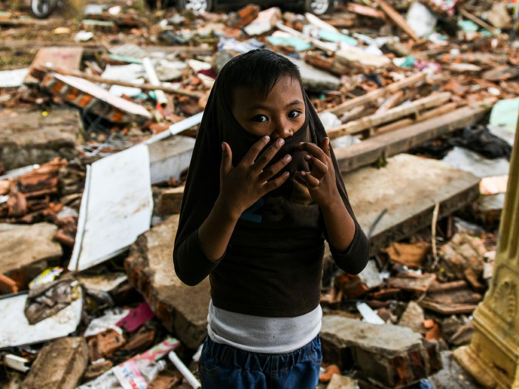 A Boy Covers His Face As He Stands Outside A Collapsed - Tsunami - HD Wallpaper 