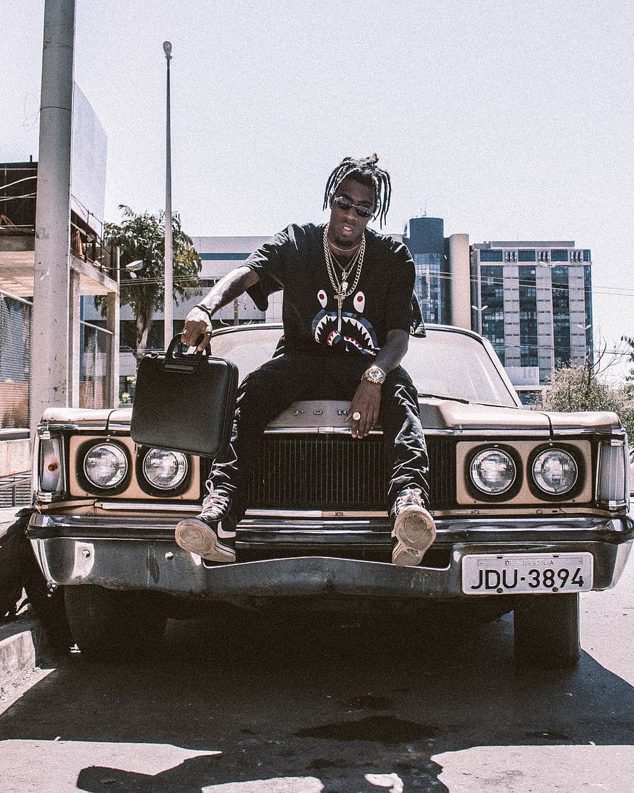 Photo Of Man Holding Black Bag Sitting On Car Hood, - Black Man Sitting In Car - HD Wallpaper 