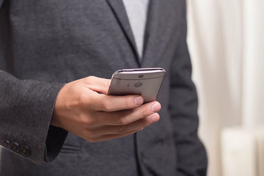 Man In Black Suit Holding Htc One M8 Smartphone, Telephone, - Businessman Holding Phone Free - HD Wallpaper 