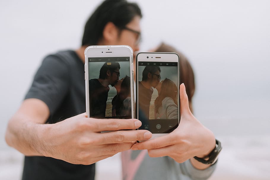Couple Holding Out Two Phones, Technology, Photography - Kissing Books - HD Wallpaper 