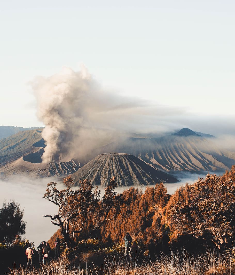 Person Standing On Cliff With Volcano Background, Erupting - Mount Bromo - HD Wallpaper 
