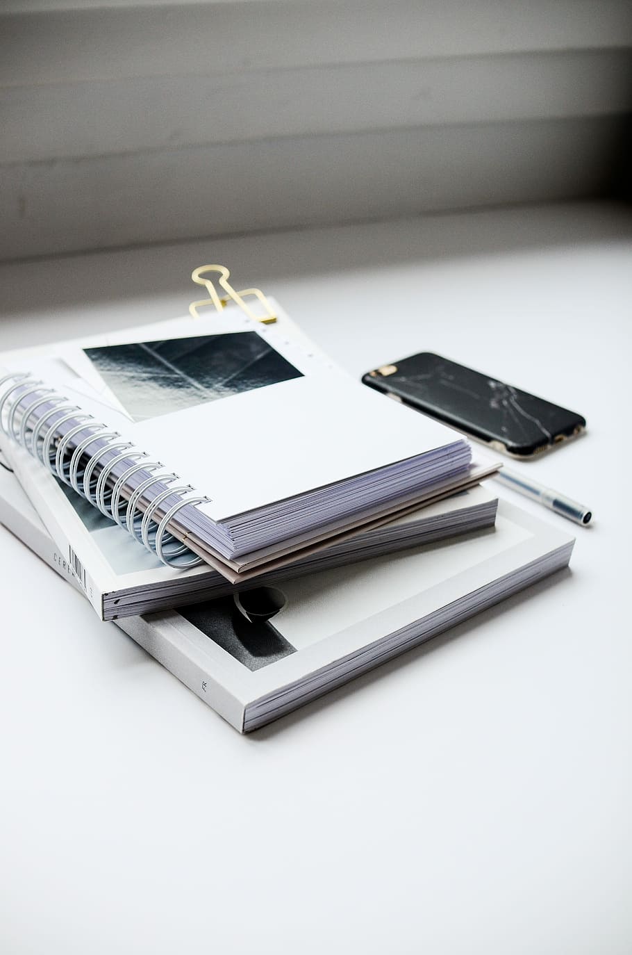 White Spiral Notebook Beside Black Smartphone On White - Iphone Books - HD Wallpaper 